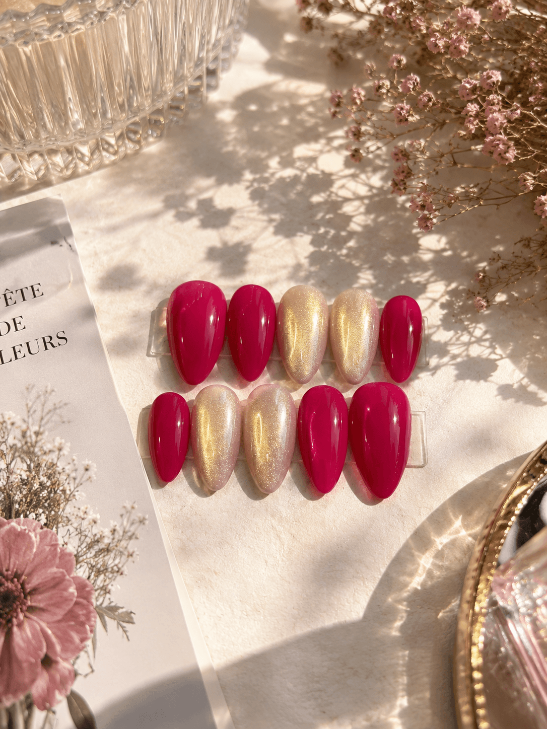 Berry Gold Shimmer — Bold magenta-pink nails paired with shimmering champagne-gold accents
