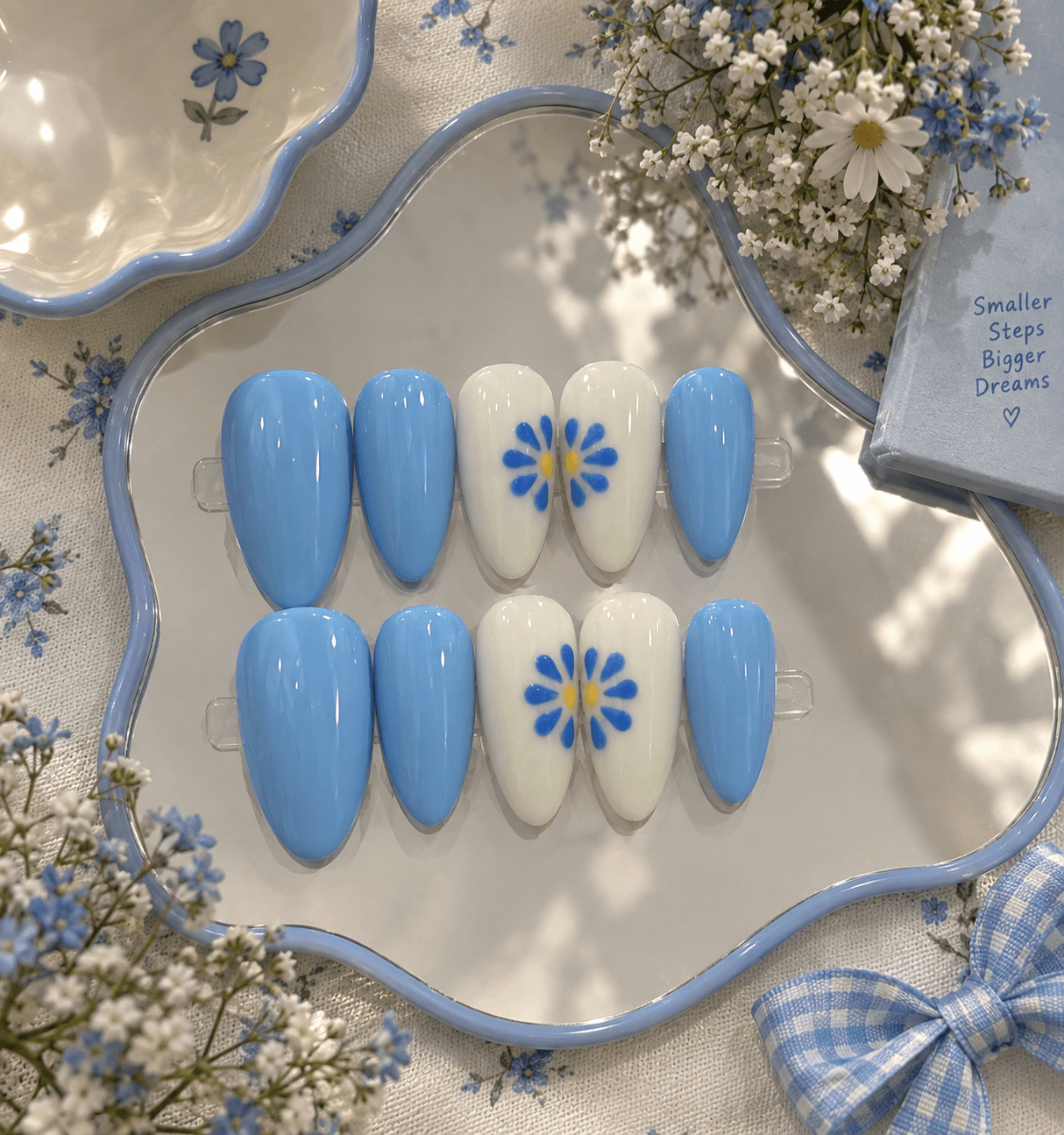 Bluebell Daisy - L size — Glossy sky-blue almond nails with white accent nails and hand-painted blue daisies.