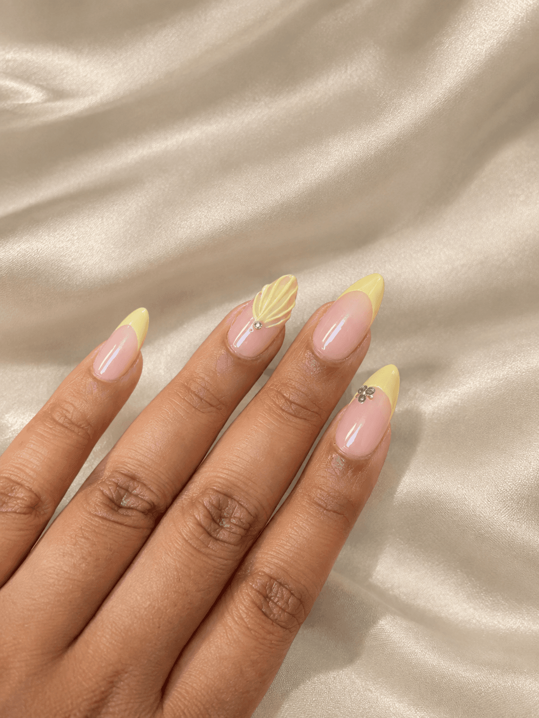 Blueberry Butter Shell🫐🐚 — Soft butter-yellow French tips with a 3D shell accent and blueberry gem details, on almond nails.