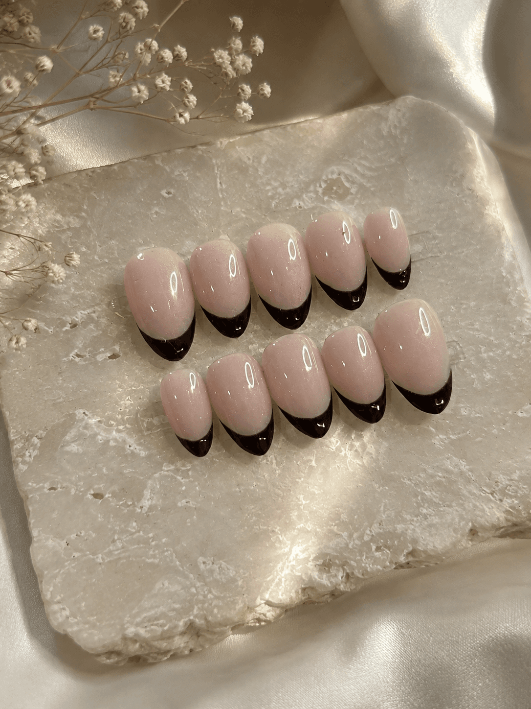 Nude Noir Tips — Sheer nude nails with a modern black French tip — minimal and chic.