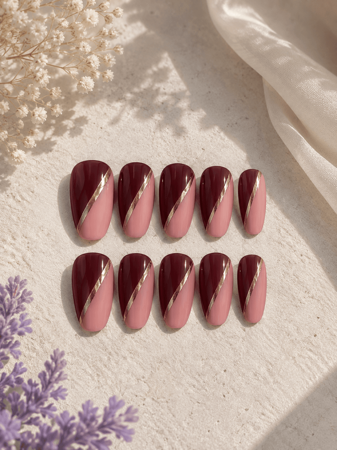 Wine & Rose Slant — Wine-red and dusty rose color-block nails with a sleek gold diagonal divide.